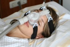 Patientin mit Schlafmaske im Schlaflabor des St. Joseph-Stift. Bei der CPAP-Therapie der Schlafapnoe wird in den Atemwegen ein leichter Überdruck erzeugt.
